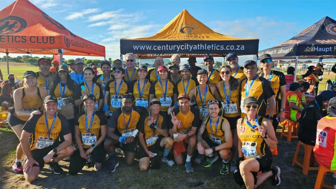 Century City runners in gold and black celebrating together after a race