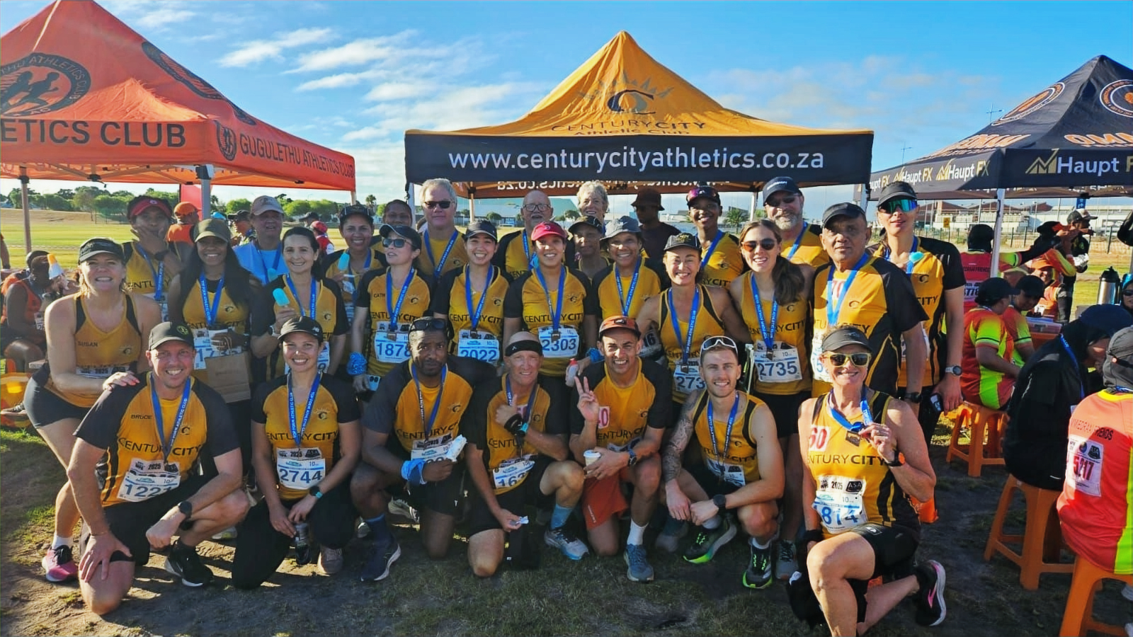 Century City runners in gold and black celebrating together after a race